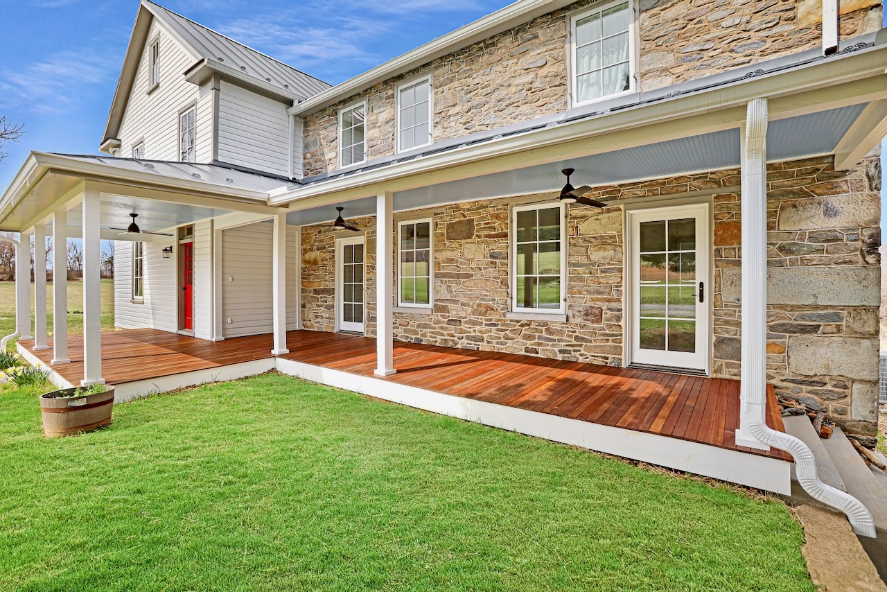 house exterior with natural stone walls and hardwood porch flooring