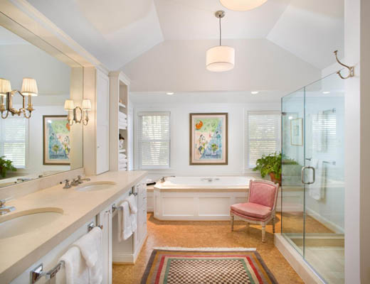 renovated bathroom with white cabinets and fixtures, bath, enclosed shower, and double sinks