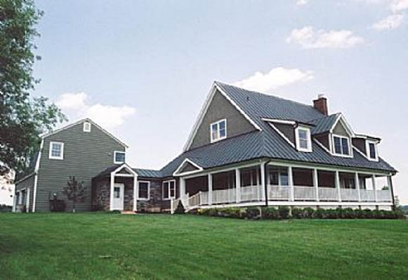 Exterior photo of renovated home on a green lawn with a metal roof