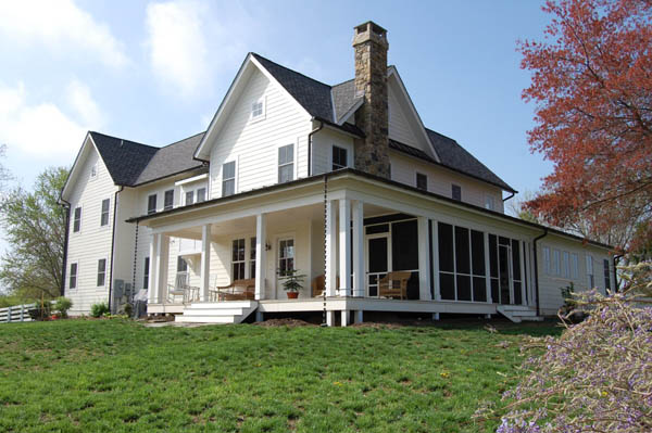exterior of a farmhouse-style home with white exterior and a screened porch