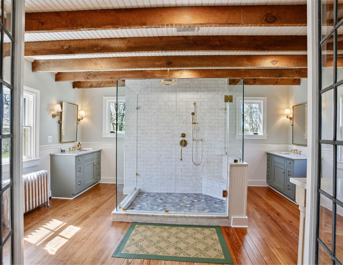 overall primary bathroom renovation in historic home exposed wood rafters with bead board ceiling marble shower tile and wood floors